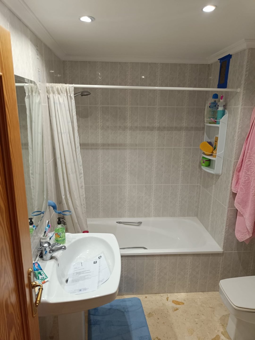 Old bathroom with a built-in bath, curtain and pedestal basin