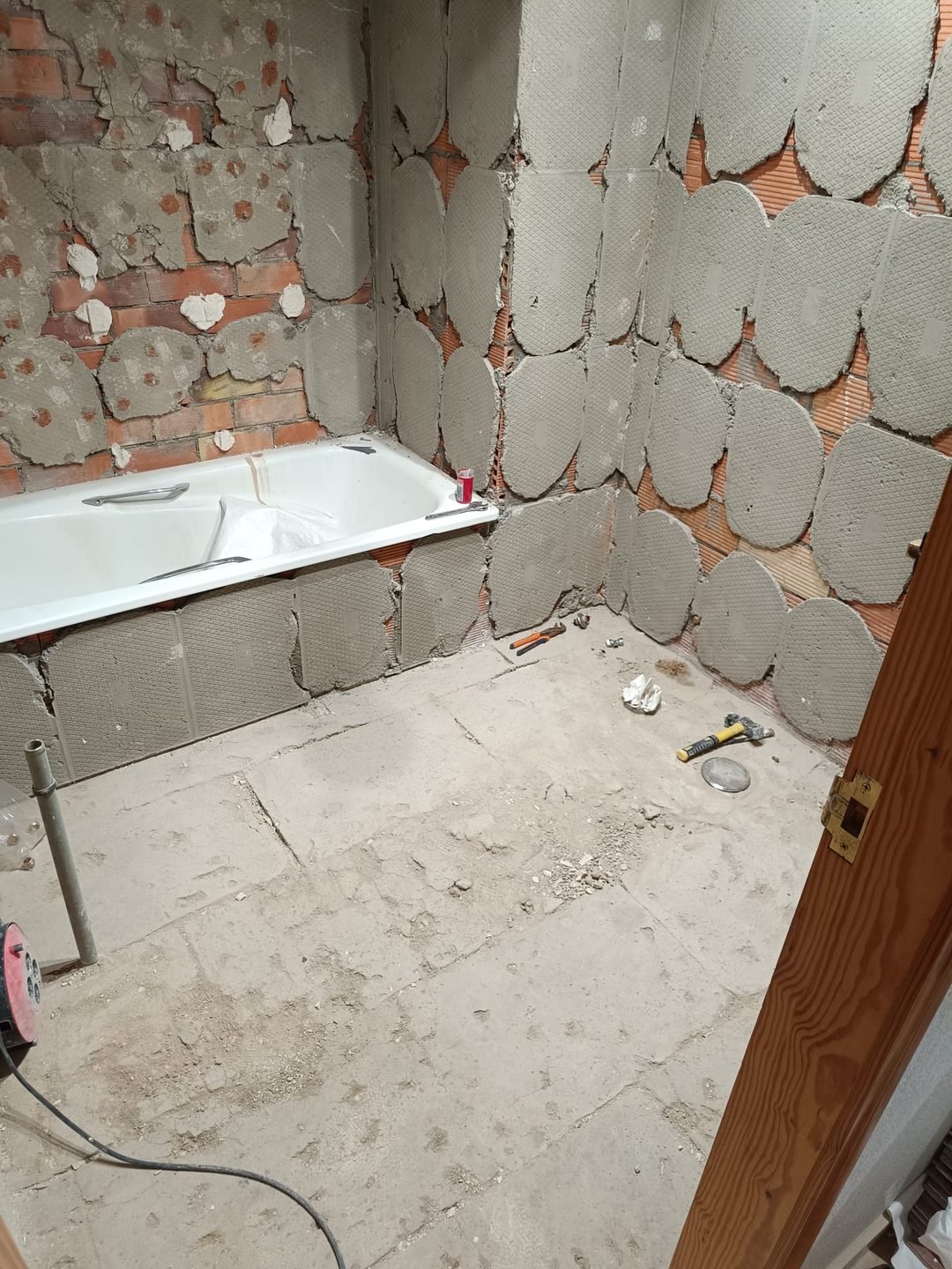 Bathroom stripped back to the brick with the new bath already in place