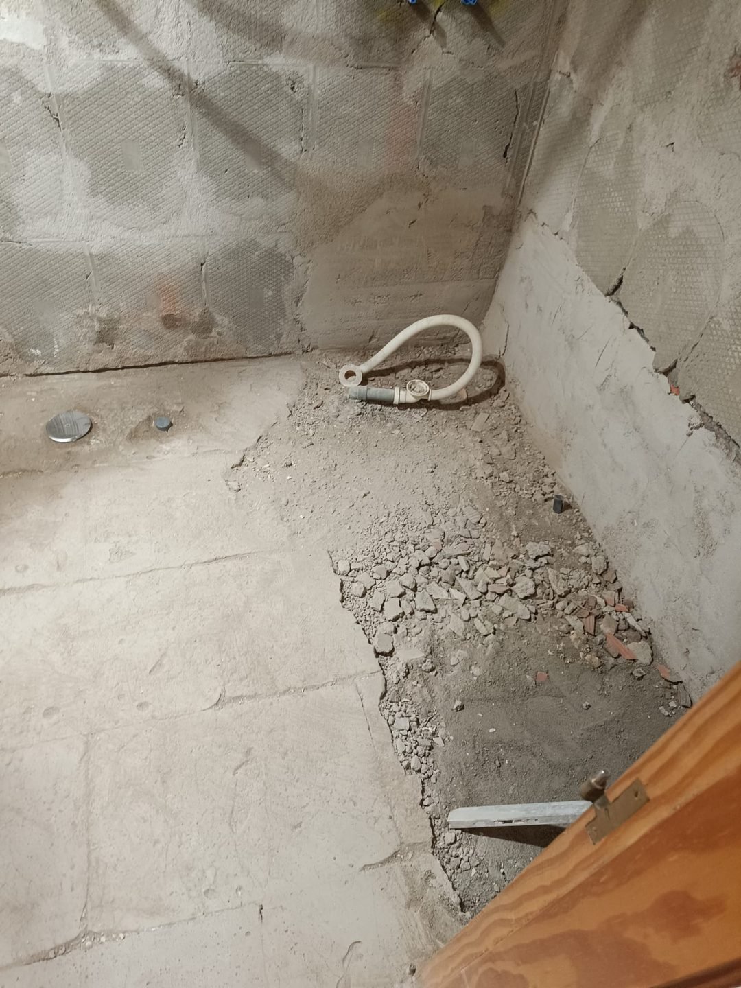 Baño picado con el suelo levantado y los desagües a la vista