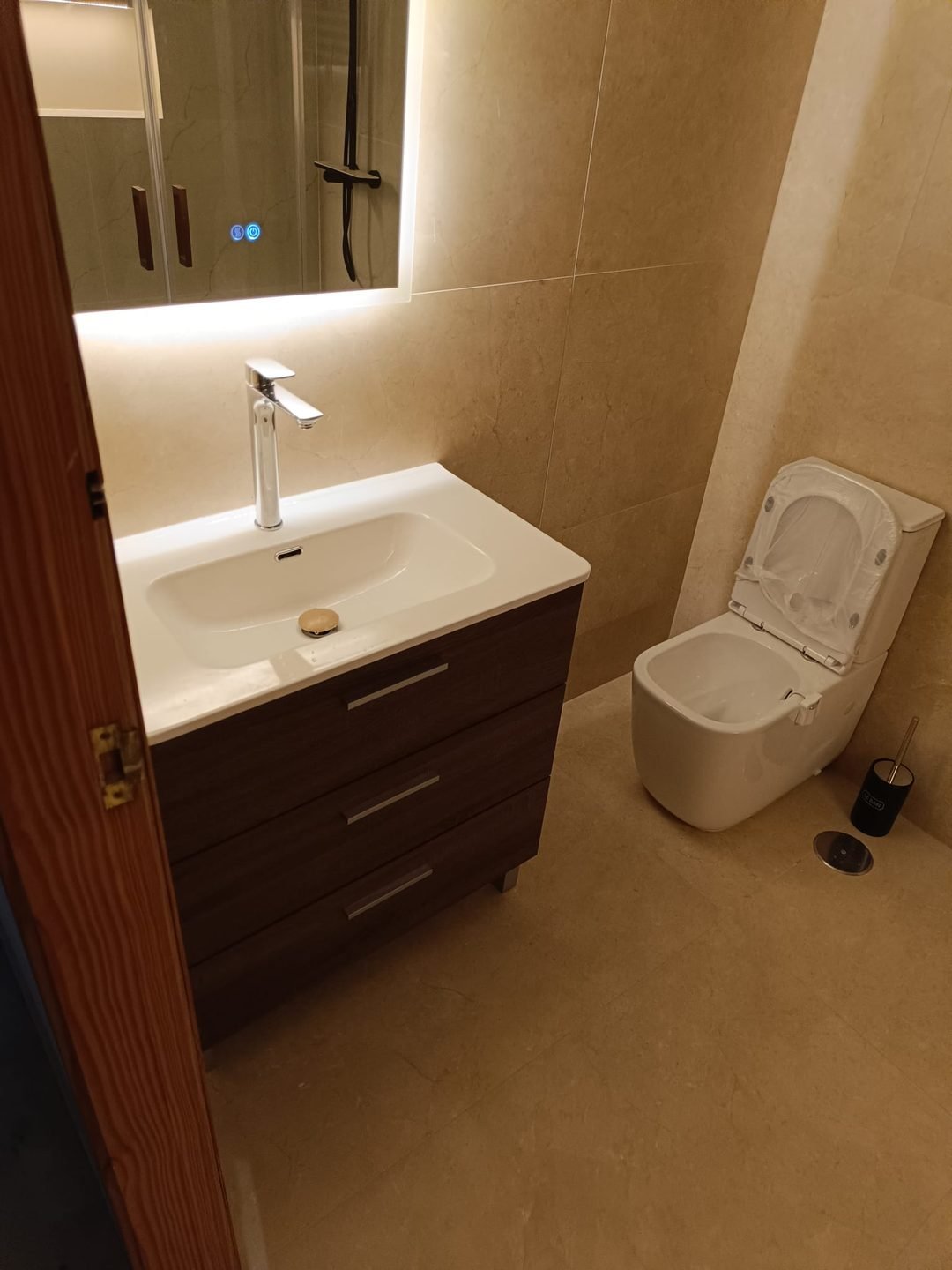 Mueble de madera oscura con lavabo integrado y grifería cromada