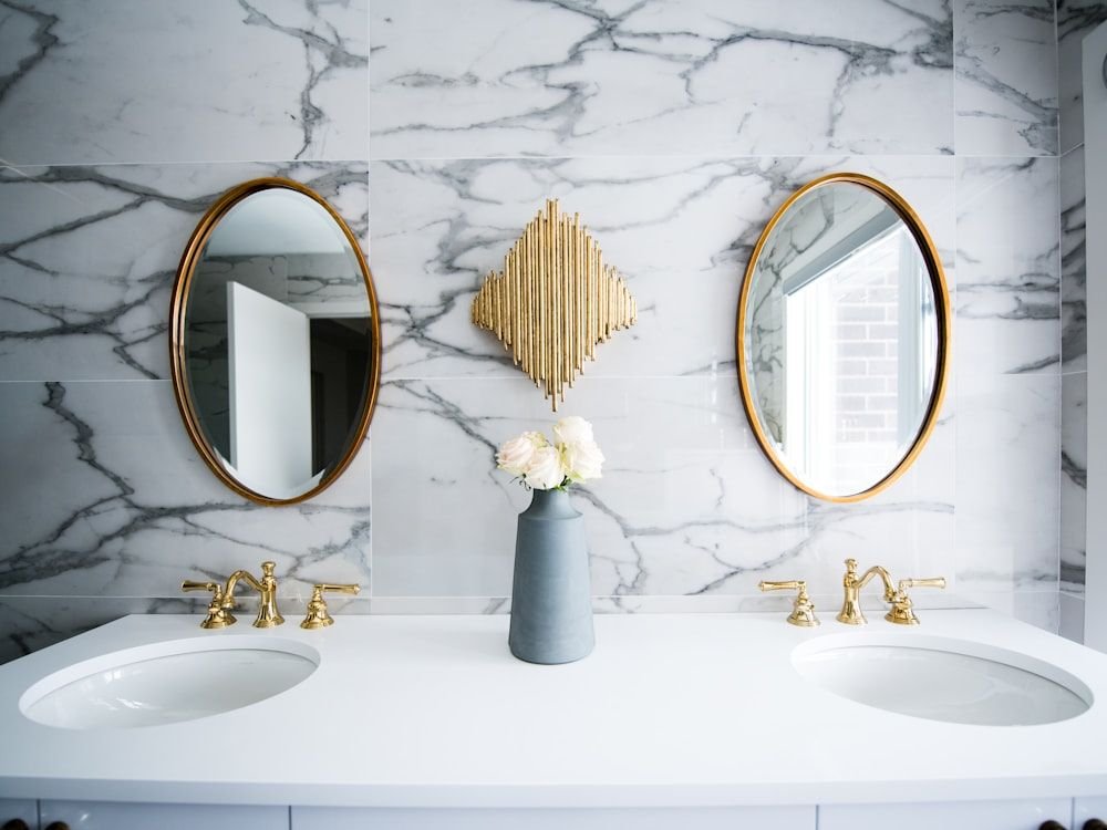 Mueble de baño suspendido con doble lavabo y espejos redondos con marco dorado