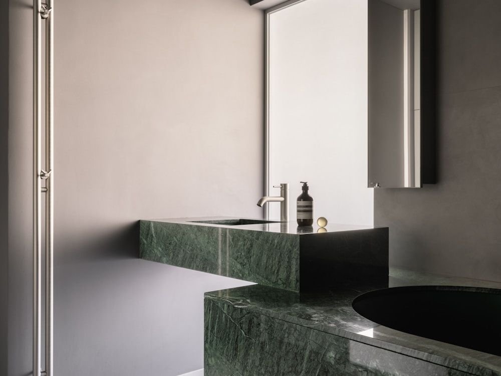 Pared de mármol verde con veta marcada en un baño contemporáneo