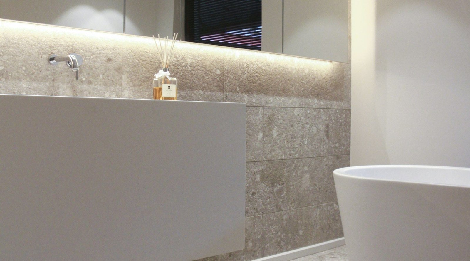 Baño reformado en tonos cálidos con iluminación indirecta