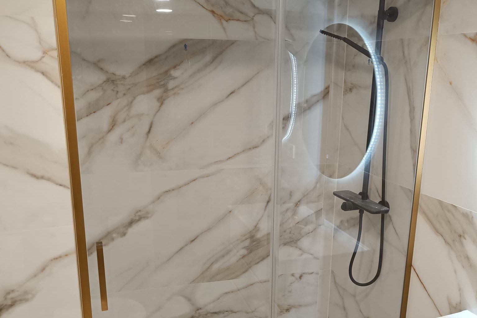 Gold framed sliding screen over veined porcelain