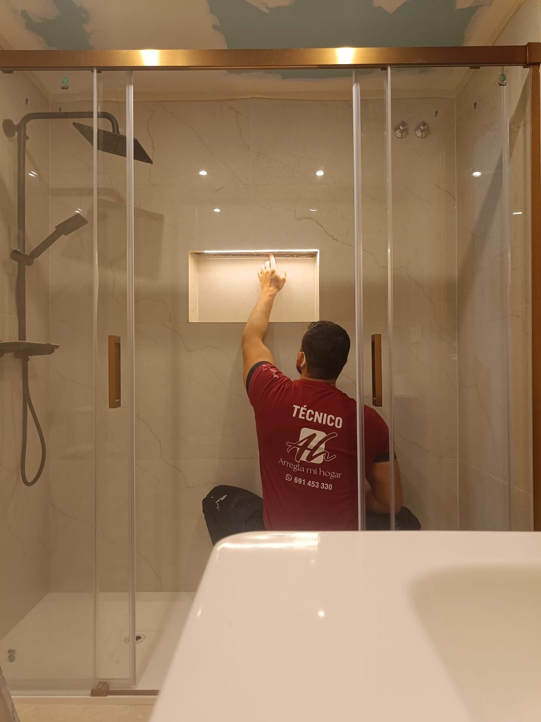 Técnico de Arregla mi hogar rematando una hornacina dentro de una ducha ya alicatada