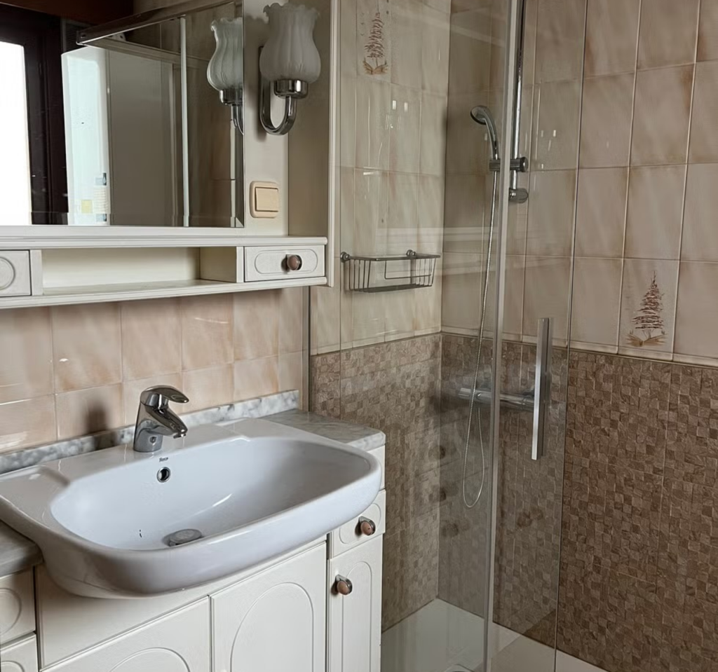 Estilo antes reforma baño con ducha, fregadero y espejo
